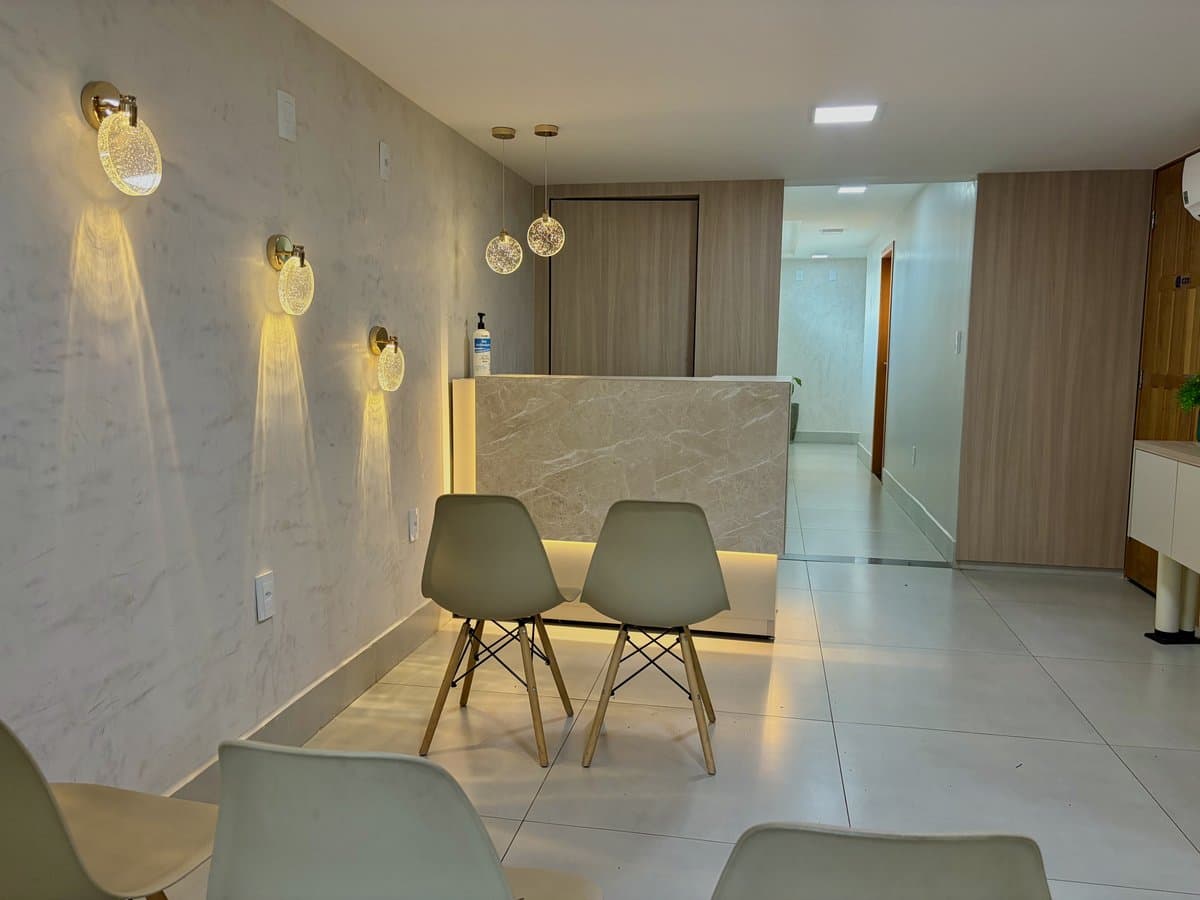 Sala de espera com cadeiras confortáveis e iluminação acolhedora